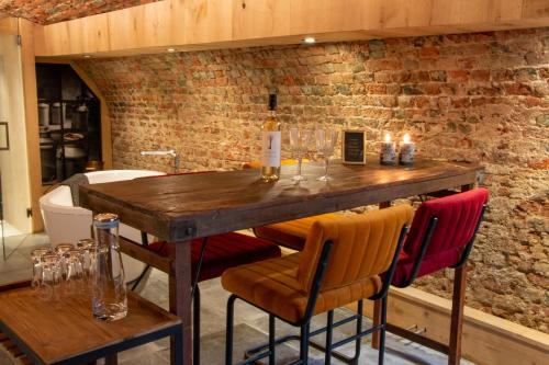 een houten tafel met stoelen en een fles wijn bij Zeeuws onder-onsje in Middelburg
