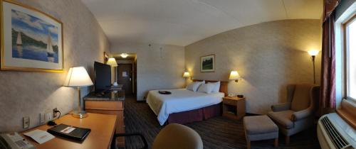 Pokój hotelowy z łóżkiem i biurkiem w obiekcie Humphry Inn and Suites w mieście Winnipeg