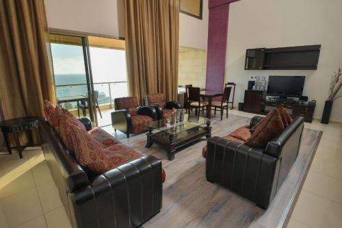 a living room with leather couches and a television at Hollywood Inn Boutique Hotel in Jounieh