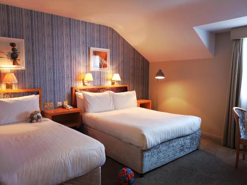 a hotel room with two beds and two lamps at Mellon Country Inn Hotel in Omagh