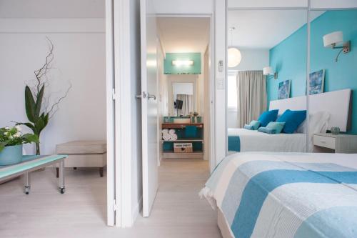 a blue and white bedroom with a bed and a table at Soho Point Central in Buenos Aires