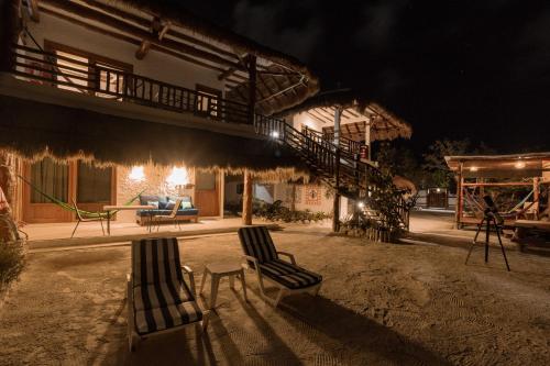 a couple of chairs sitting in front of a building at night at La Casa del Alux - Adults Only in Holbox Island