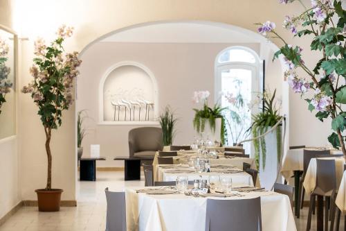 a restaurant with tables and chairs and flowers at Hotel Terme Park Imperial in Ischia