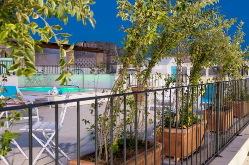 einen Balkon mit Topfbäumen und einem Pool in der Unterkunft Dimore Briganti in Gallipoli