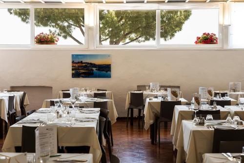 a dining room with tables with white tablecloths at Hotel Terme Park Imperial in Ischia