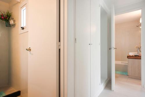 a bathroom with white walls and a door with a mirror at Soho Point Central in Buenos Aires
