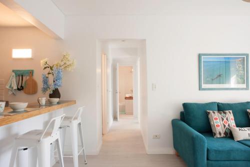 a living room with a blue couch and a kitchen at Soho Point Central in Buenos Aires