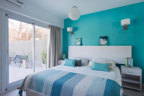 a blue bedroom with a bed and a large window at Soho Point Central in Buenos Aires
