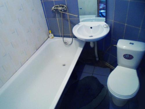 uma casa de banho com um WC, uma banheira e um lavatório. em Дом em Okhtyrka