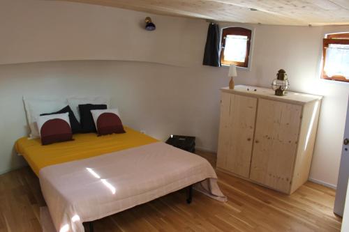 ein Schlafzimmer mit einem Bett, einem Schrank und einem Fenster in der Unterkunft studio sur péniche La Tortue in Ramonville-Saint-Agne