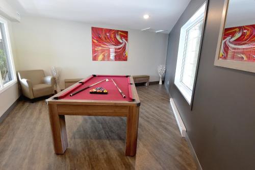 a room with a pool table in a room at Hôtel et Pavillons Le Petit Manoir du Casino in La Malbaie