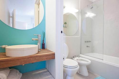 a bathroom with a sink and a toilet and a mirror at Soho Point Central in Buenos Aires