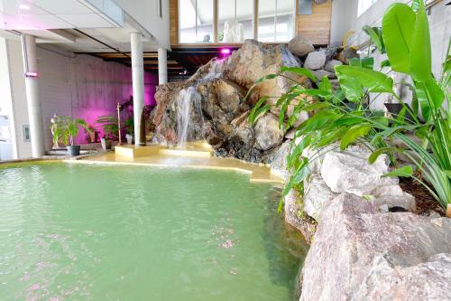 a large pool of water with a waterfall at Hôtel Le Petit Manoir du Casino in La Malbaie