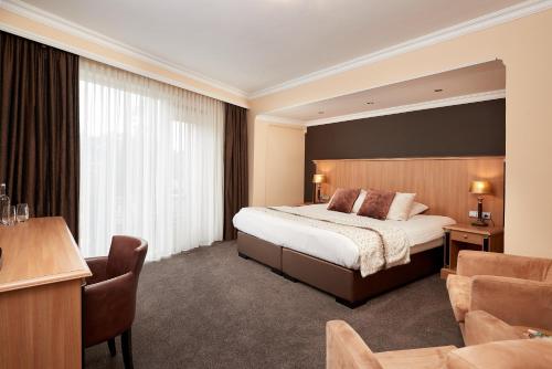 a hotel room with a bed and a desk at Van der Valk Hotel Hardegarijp - Leeuwarden in Hardegarijp