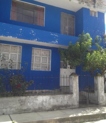 uma casa azul com uma cerca em frente em Chaska House BB em Huaraz