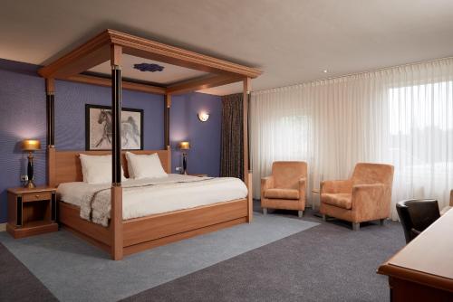 Van der Valk Hotel Hardegarijp - Leeuwarden في Hardegarijp: غرفة نوم بسرير مظلة وكرسيين