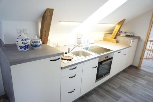 a kitchen with white cabinets and a sink at Ferienhaus Lusatia am Töpfer in Kurort Oybin