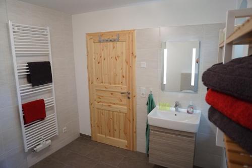 a bathroom with a sink and a wooden door at Ferienhaus Lusatia am Töpfer in Kurort Oybin