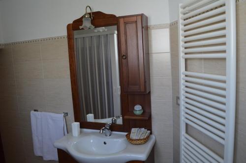 ein Bad mit einem Waschbecken und einem Spiegel in der Unterkunft Casa Vacanze La Foggia in Alberobello