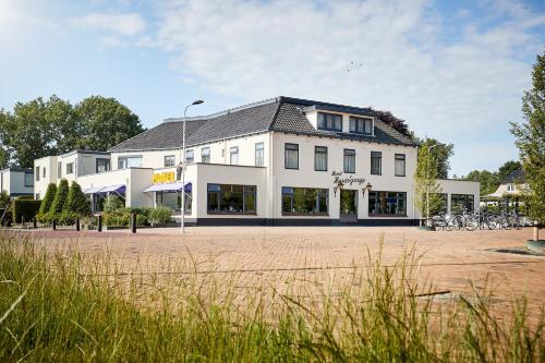 a large white building with bikes parked in front of it at Van der Valk Hotel Hardegarijp - Leeuwarden in Hardegarijp