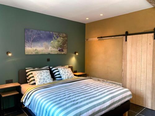 a bedroom with a large bed with green walls at De Bonderbei in Wellen