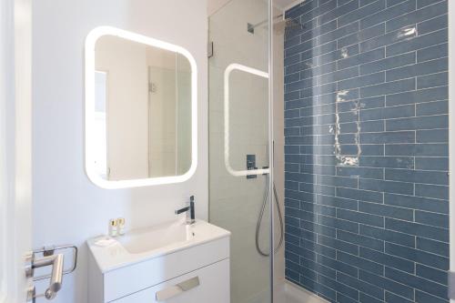 ein Bad mit einem Waschbecken und einer Dusche mit einem Spiegel in der Unterkunft FLH Anjos Lovely Apartment in Lissabon