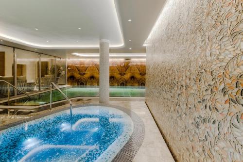 
a large swimming pool with a large mirror at Grand Poet Hotel and SPA by Semarah in Riga
