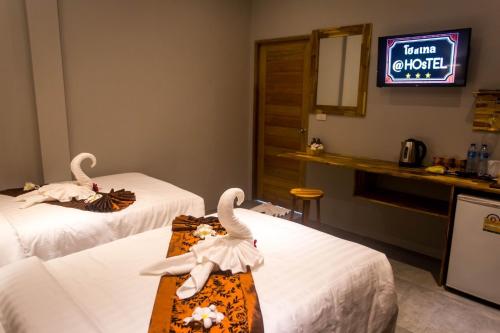 two swans sitting on beds in a hotel room at @HOsTEL PHANGAN in Baan Tai