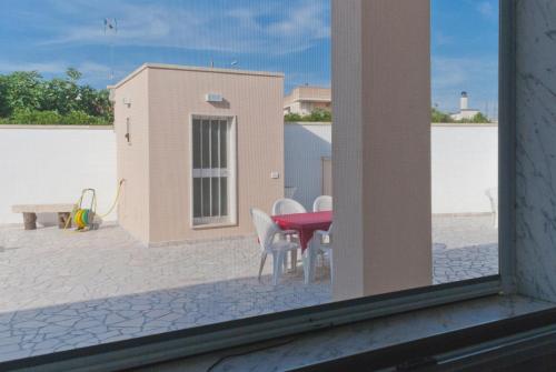 a patio with a red table and white chairs at B&B Mamma Carolina in Sanarica