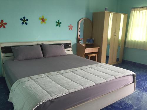 una camera da letto con un letto grande e uno specchio di goodluck resort@phayao a Phayao