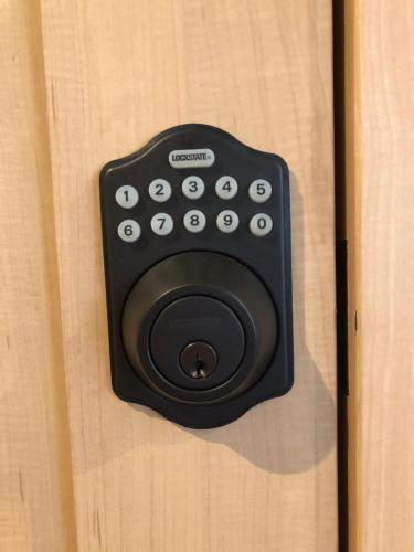 a black remote control sitting on a wooden door at Oyado Zen in Kusatsu