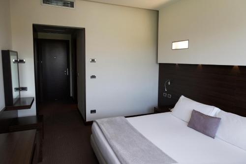 a hotel room with a bed and a door at Hotel Selene Pomezia in Pomezia