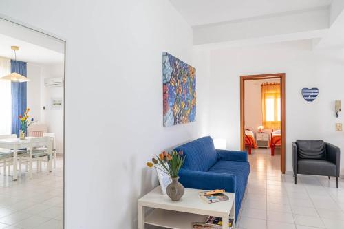 a living room with a blue couch and a table at Palms Villa in Scopello