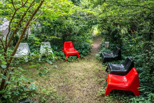 three red and black chairs sitting in a garden at Gruppenhaus Darmstadt in Darmstadt