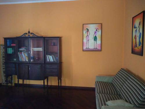 a living room with a couch and a cabinet and paintings at Bella di notte in San Giorgio a Liri