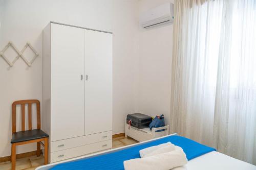 a bedroom with a bed and a large white cabinet at Palms Villa in Scopello