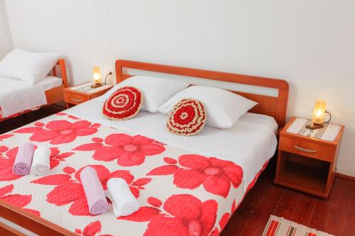 a bedroom with a bed with red flowers on it at Holiday HomeToni in Savar