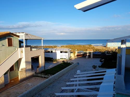 una vista sulla spiaggia dal balcone di un edificio di Casa La Rosa - Residence Rada delle Tortore a Marzamemi