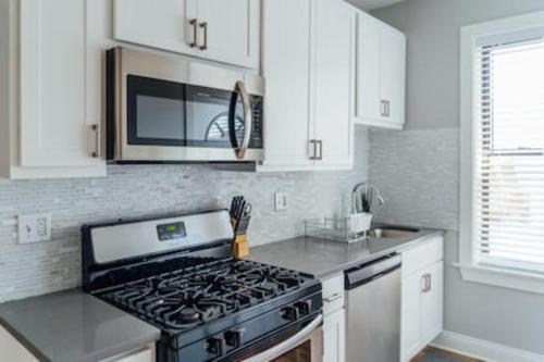 a kitchen with a stove and a microwave at Convenient & Newly Decorated 1BR Apartment - Roscoe 1D in Chicago