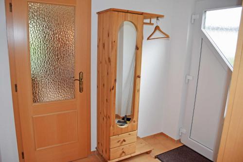 Habitación con espejo junto a una puerta de madera. en ruhig gelegene Ferienwohnung am Ne, en Sandort