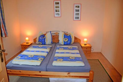 a bedroom with two beds with blue sheets and two lamps at ruhig gelegene Ferienwohnung am Ne in Sandort