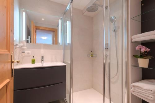 uma casa de banho com um lavatório e um chuveiro em Hotel Traube em Pettneu am Arlberg