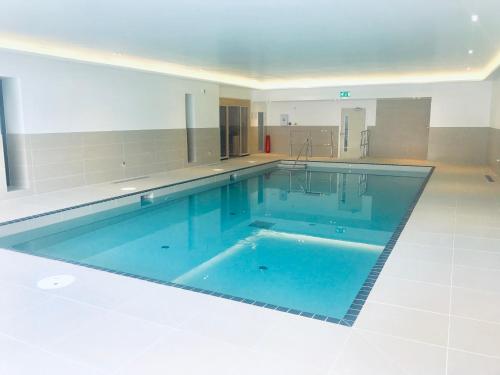 una gran piscina en el medio de una habitación en 8 Woolacombe West - Luxury Apartment at Byron Woolacombe, only 4 minute walk to Woolacombe Beach!, en Woolacombe