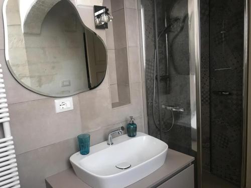 La salle de bains est pourvue d'un lavabo, d'une douche et d'un miroir. dans l'établissement Casa La Stella, à Martina Franca