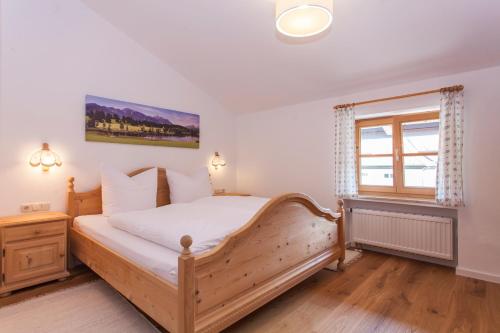 a bedroom with a wooden bed and a window at Fewo Schönes Ammertal in Oberammergau