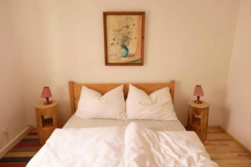 a bedroom with a bed with white sheets and two lamps at Barbara Residenz / Apartment Clematis in Eisenerz