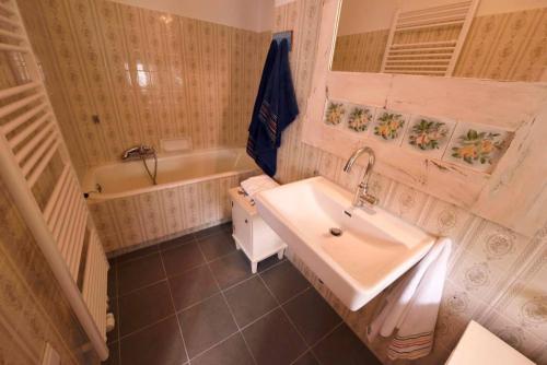 La salle de bains est pourvue d'un lavabo et d'une baignoire. dans l'établissement Barbara Residenz / Apartment Clematis, à Eisenerz