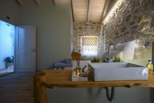 eine Küche mit einem Waschbecken und einer Steinmauer in der Unterkunft Paxos Fairytales Lovenest 1 in Gaios
