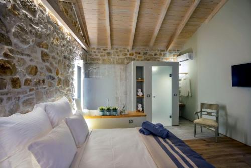 ein Wohnzimmer mit einem Sofa und einer Steinmauer in der Unterkunft Paxos Fairytales Lovenest 1 in Gaios