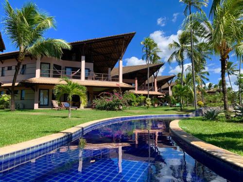 a resort with a swimming pool in front of a building at Dream Beach Cumbuco Oceanfront Apartments in Cumbuco